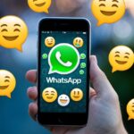 Um smartphone com o logotipo do WhatsApp na tela, cercado por balões de fala e emojis